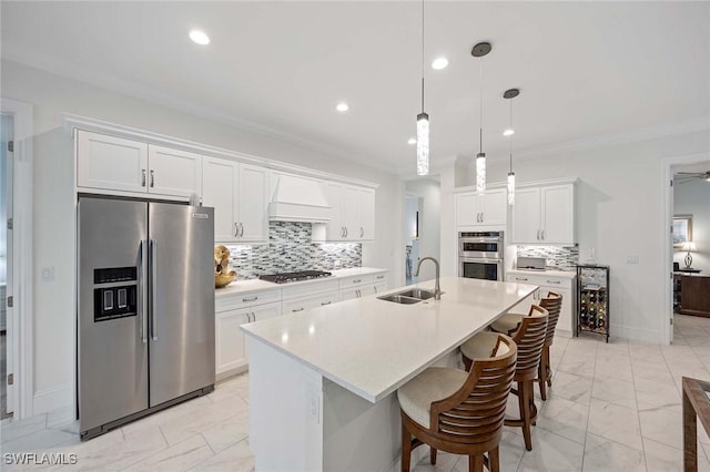 kitchen with light countertops, ornamental molding, appliances with stainless steel finishes, marble finish floor, and a sink