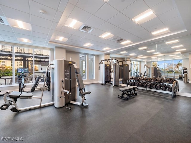 workout area with a paneled ceiling, visible vents, and baseboards