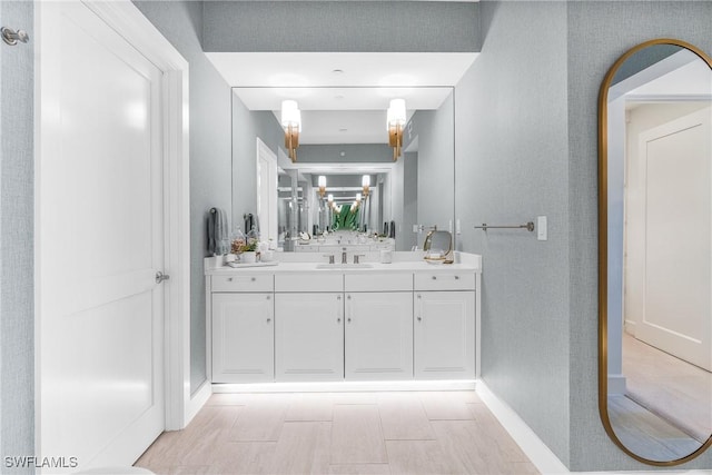 bathroom with vanity, baseboards, and wood finished floors