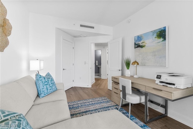 office area with baseboards, visible vents, and wood finished floors