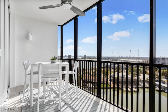 sunroom featuring a ceiling fan and a view of city