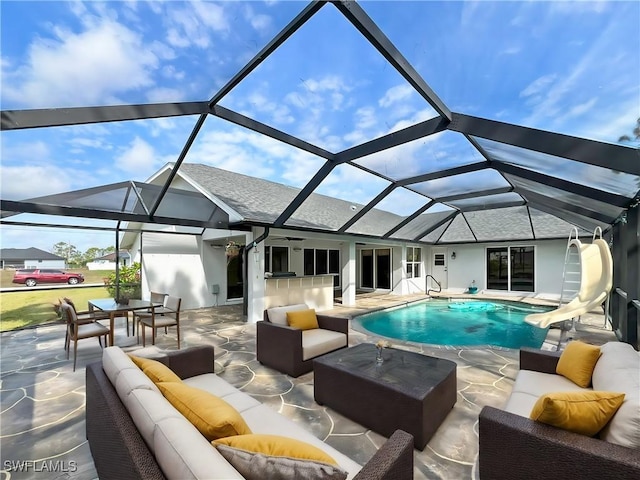 pool with a patio, a water slide, and an outdoor living space