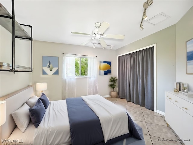 bedroom with a ceiling fan, baseboards, track lighting, and light tile patterned floors