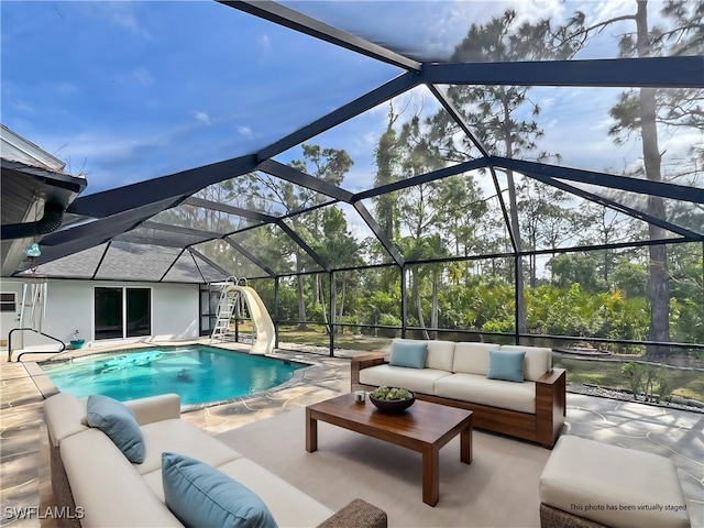 pool with a lanai, a patio area, outdoor lounge area, and a water slide