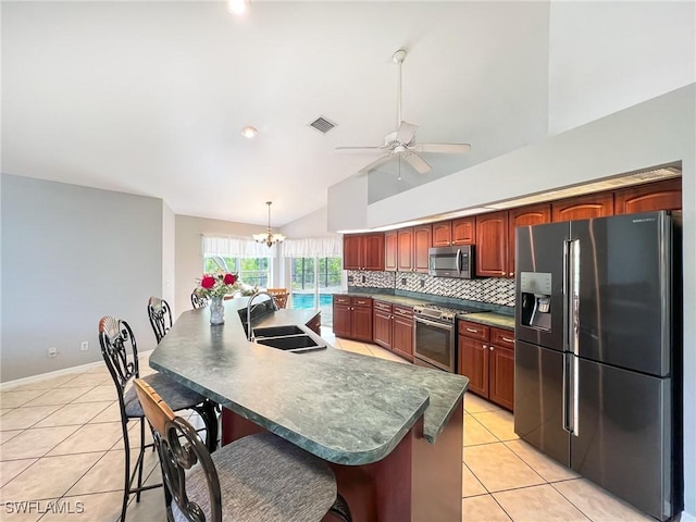 kitchen with light tile patterned floors, visible vents, decorative backsplash, appliances with stainless steel finishes, and a sink