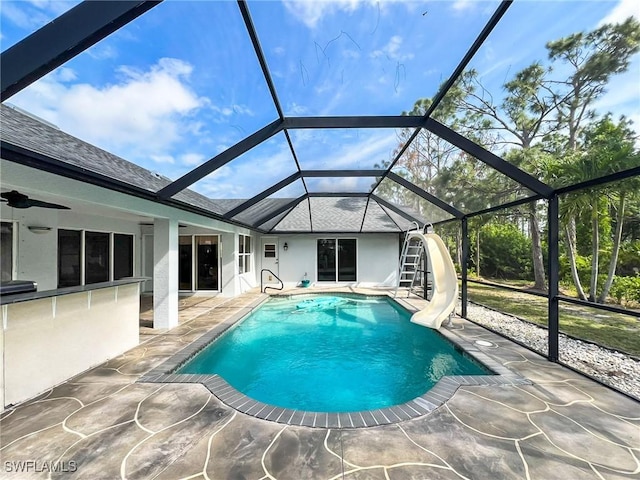 pool with a ceiling fan, a water slide, a patio area, and a lanai