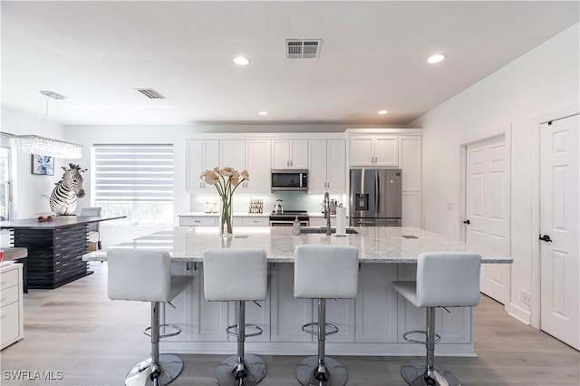 kitchen featuring a sink, visible vents, light wood-type flooring, and appliances with stainless steel finishes