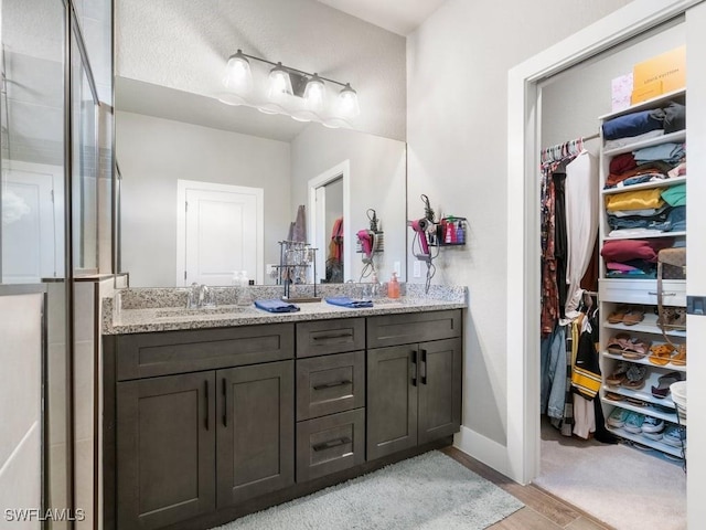 509 SW 8th Ct, Cape Coral, FL 33991 - full bathroom with a spacious closet, vanity, wood finished floors, and baseboards