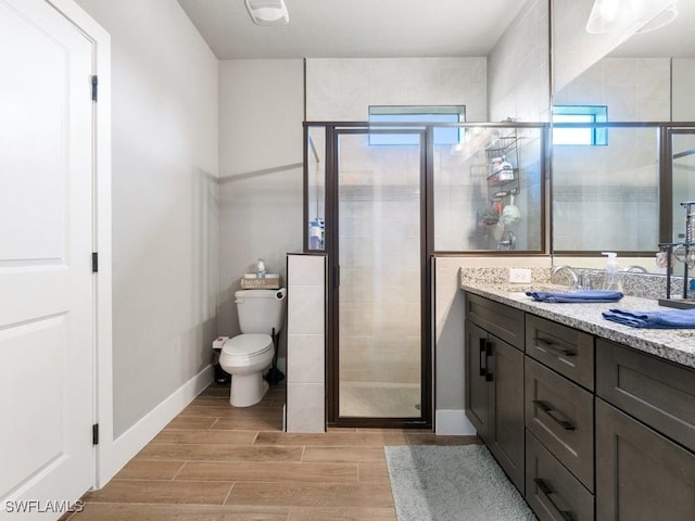 509 SW 8th Ct, Cape Coral, FL 33991 - bathroom featuring a stall shower, wood finish floors, vanity, toilet, and baseboards