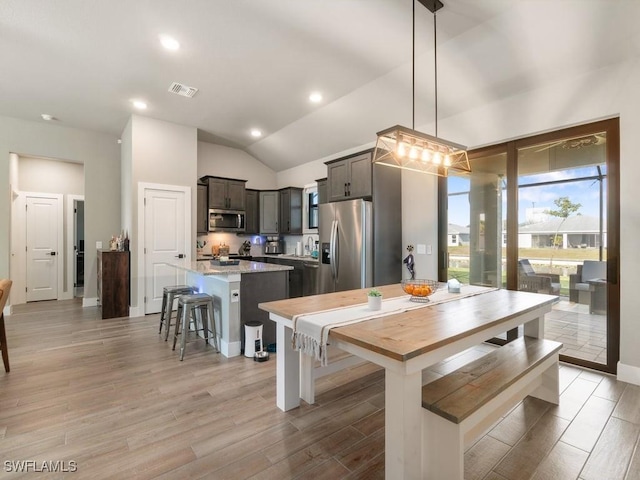 509 SW 8th Ct, Cape Coral, FL 33991 - dining space featuring light wood finished floors, vaulted ceiling, recessed lighting, and baseboards