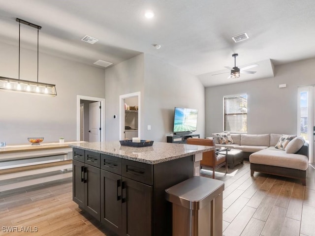 509 SW 8th Ct, Cape Coral, FL 33991 - kitchen featuring light wood finished floors, a ceiling fan, light stone counters, decorative light fixtures, and open floor plan