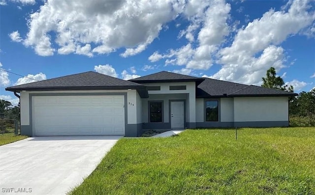 prairie-style home featuring an attached garage, a front yard, concrete driveway, and stucco siding