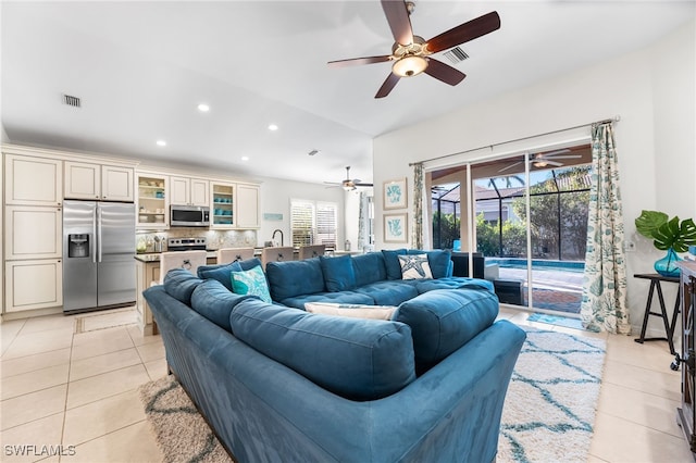 living room with a sunroom, visible vents, and light tile patterned flooring