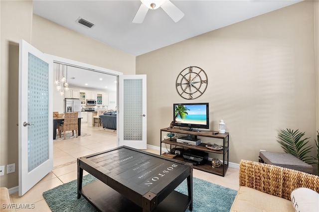 living area featuring a ceiling fan, light tile patterned flooring, visible vents, and baseboards