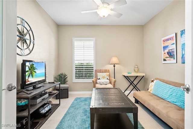 tiled living area with a ceiling fan and baseboards