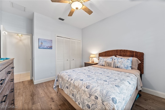 bedroom featuring a closet, wood finished floors, visible vents, and baseboards