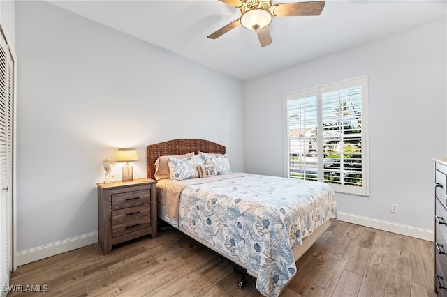 bedroom with a ceiling fan, a closet, light wood-style flooring, and baseboards