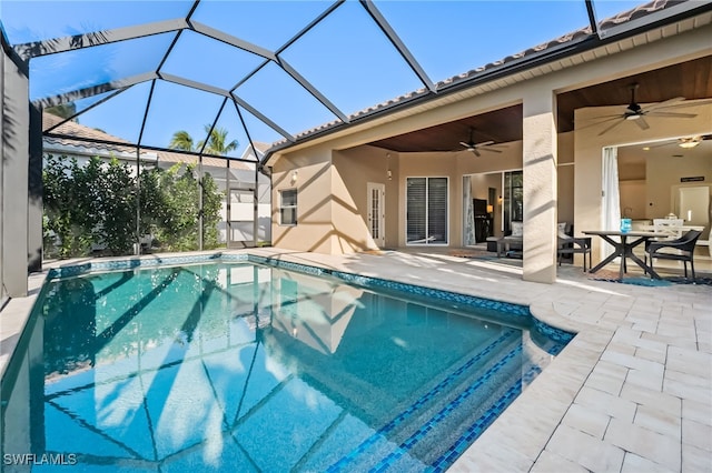 pool featuring glass enclosure, a patio area, and a ceiling fan