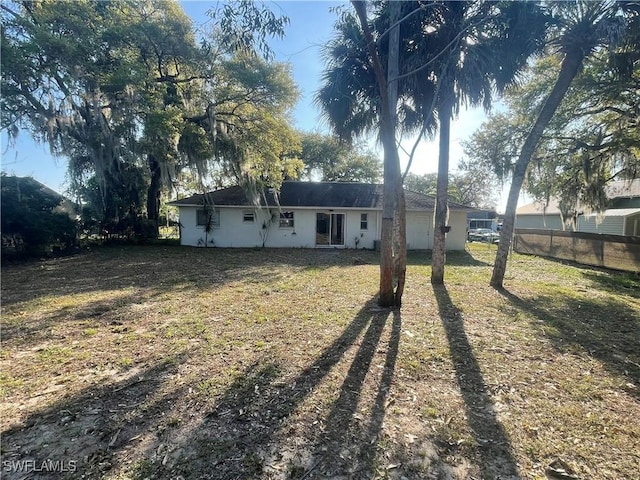 back of house featuring a garage and fence