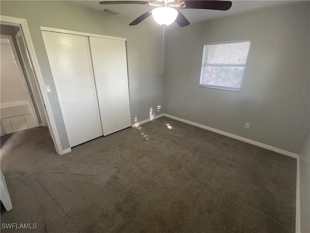 unfurnished bedroom featuring baseboards, visible vents, ceiling fan, carpet, and a closet