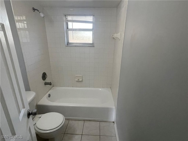 bathroom featuring toilet, tile patterned flooring, and bathing tub / shower combination