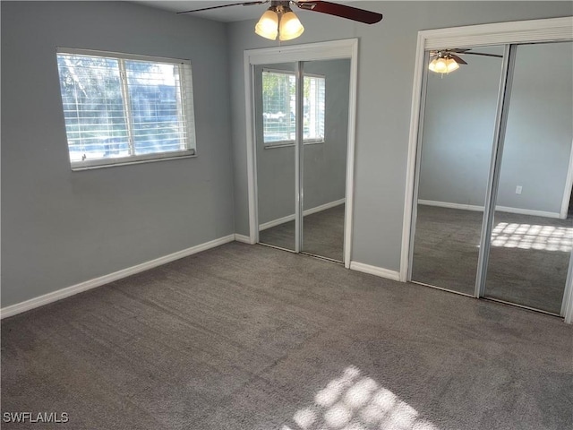 unfurnished bedroom with baseboards, carpet, a ceiling fan, and multiple closets