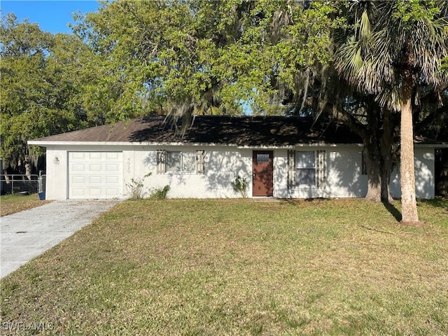 view of front of home with an attached garage, concrete driveway, a front yard, and fence