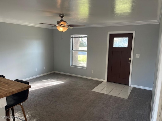 foyer entrance with crown molding, baseboards, a ceiling fan, and light colored carpet