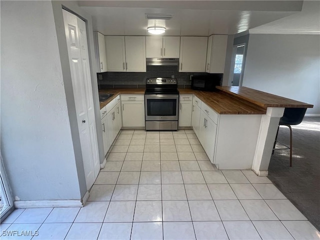 kitchen with light tile patterned floors, tasteful backsplash, under cabinet range hood, stainless steel range with electric stovetop, and black microwave