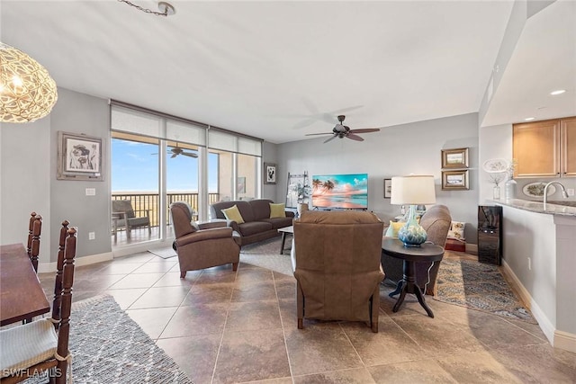 living room with floor to ceiling windows, ceiling fan, and baseboards