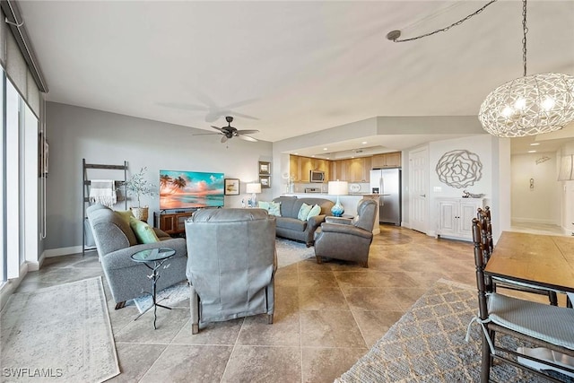 living area with a ceiling fan and baseboards