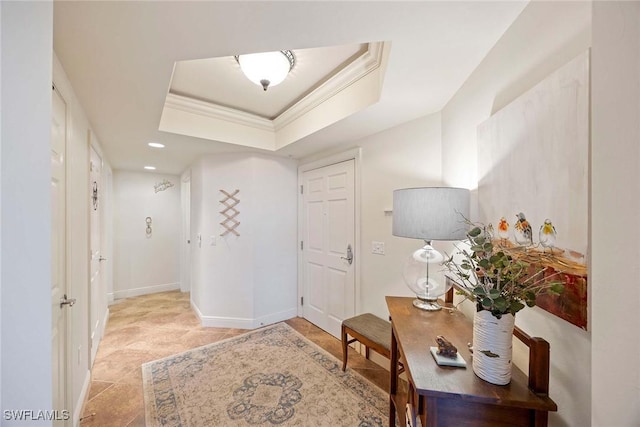 foyer featuring recessed lighting, a raised ceiling, crown molding, and baseboards