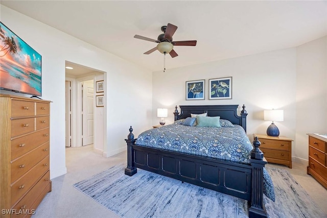 bedroom featuring light carpet, baseboards, and a ceiling fan