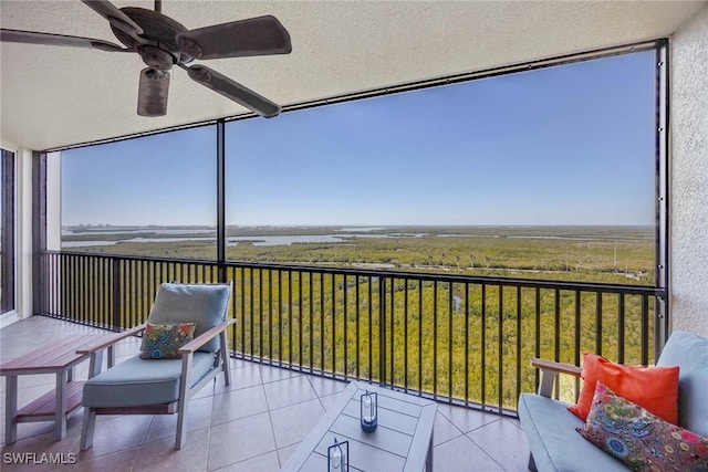 sunroom with a rural view and a ceiling fan