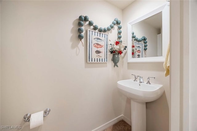 bathroom featuring baseboards and a sink