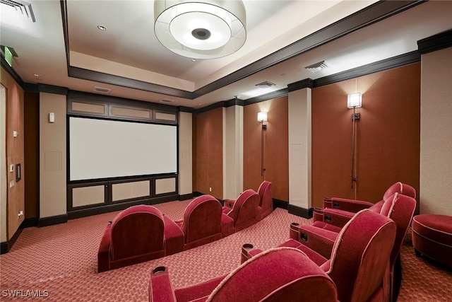 carpeted home theater room with a raised ceiling, visible vents, and baseboards