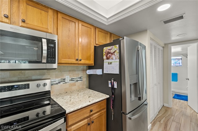 kitchen featuring tasteful backsplash, light stone countertops, appliances with stainless steel finishes, baseboards, and visible vents