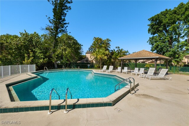 community pool featuring fence, a gazebo, and a patio area
