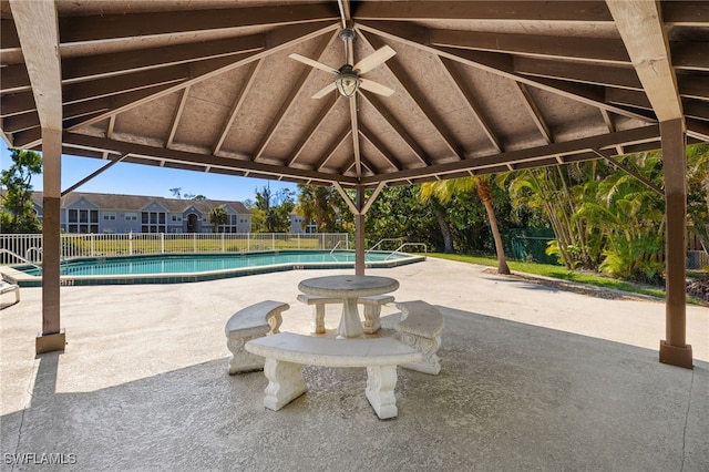 community pool featuring fence, a gazebo, a ceiling fan, and a patio area