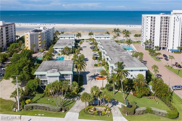 drone / aerial view featuring a beach view and a water view