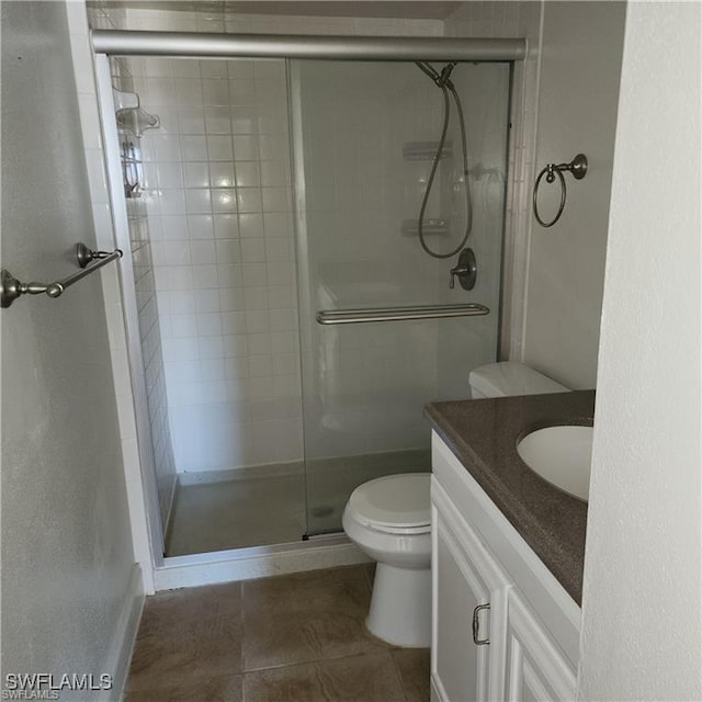 full bathroom with vanity, a shower stall, and toilet