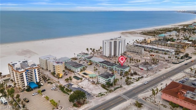 drone / aerial view with a water view, a view of city, and a beach view