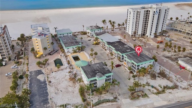 birds eye view of property with a water view and a beach view