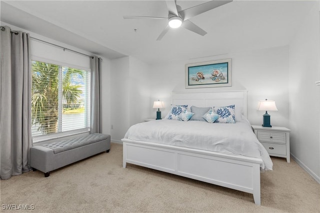 bedroom with light colored carpet, baseboards, and ceiling fan