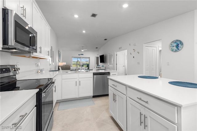 kitchen featuring visible vents, appliances with stainless steel finishes, a peninsula, white cabinetry, and a sink