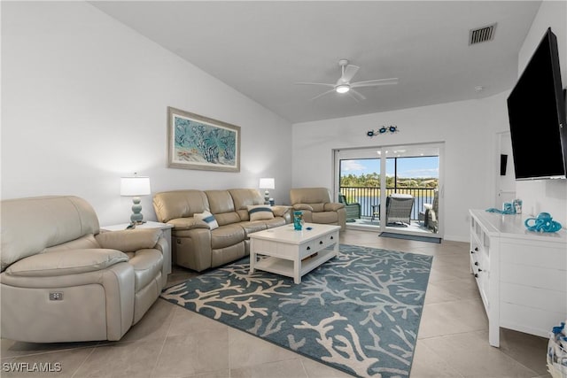 living area featuring vaulted ceiling, light tile patterned flooring, a ceiling fan, and visible vents