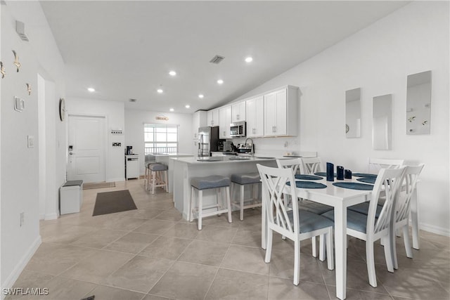 dining room with visible vents, recessed lighting, light tile patterned flooring, baseboards, and vaulted ceiling