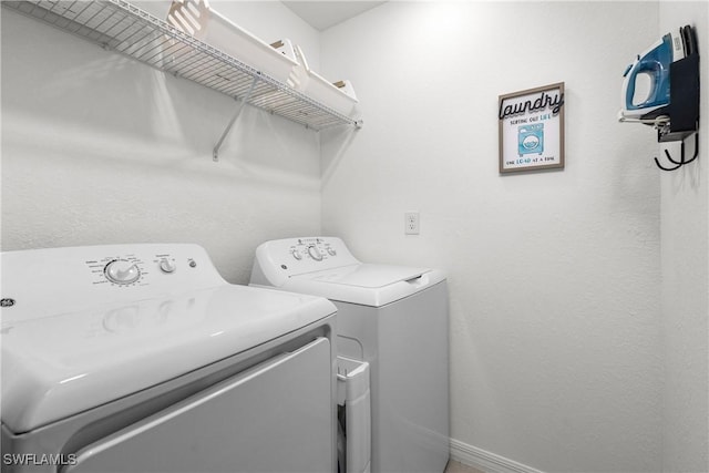 laundry room with baseboards, independent washer and dryer, and laundry area