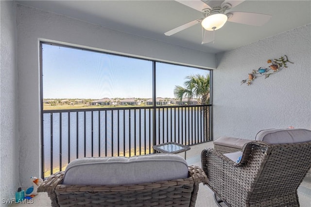 sunroom / solarium with a water view and ceiling fan