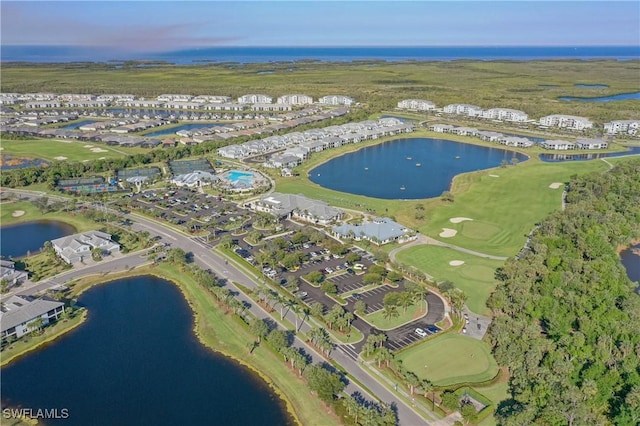 drone / aerial view with a water view and view of golf course